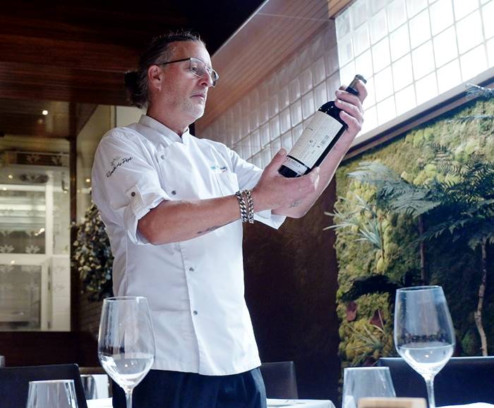 El chef Ginés Nicolás Fernández del restaurante ‘El Rincón de Pepe’ sostiene una botella del vino de Bodegas Luzón ‘Por Ti’
